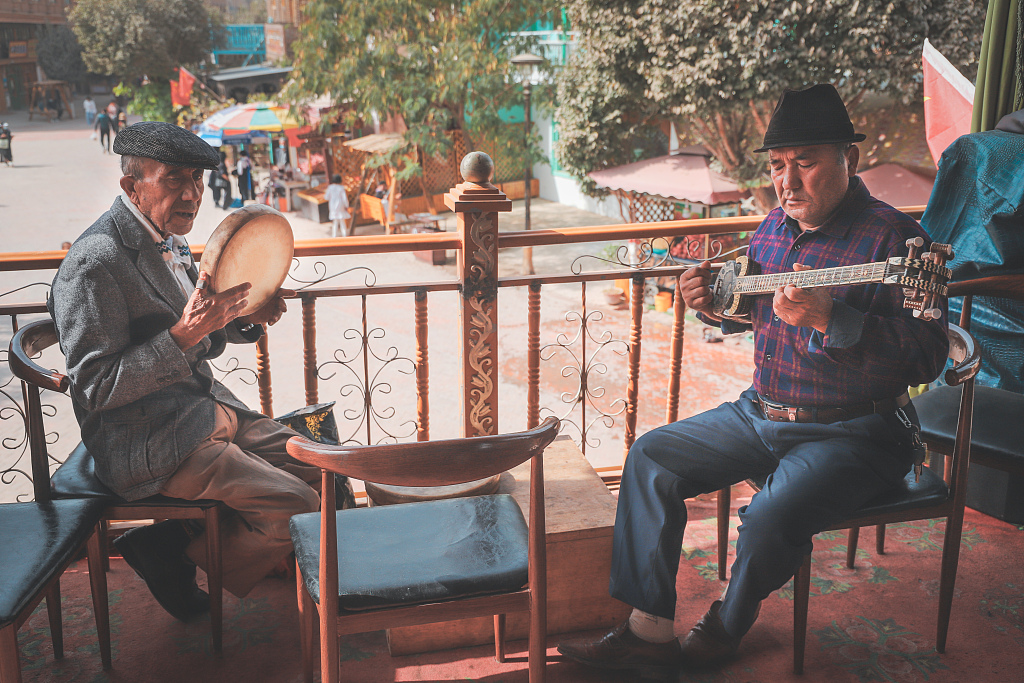 Шиньжяны Кашгарын эртний хотын нэгэн цайны мухлагт Уйгар үндэстний уран бүтээлчид ардын уламжлалт хөгжим тоглож дуулж байна